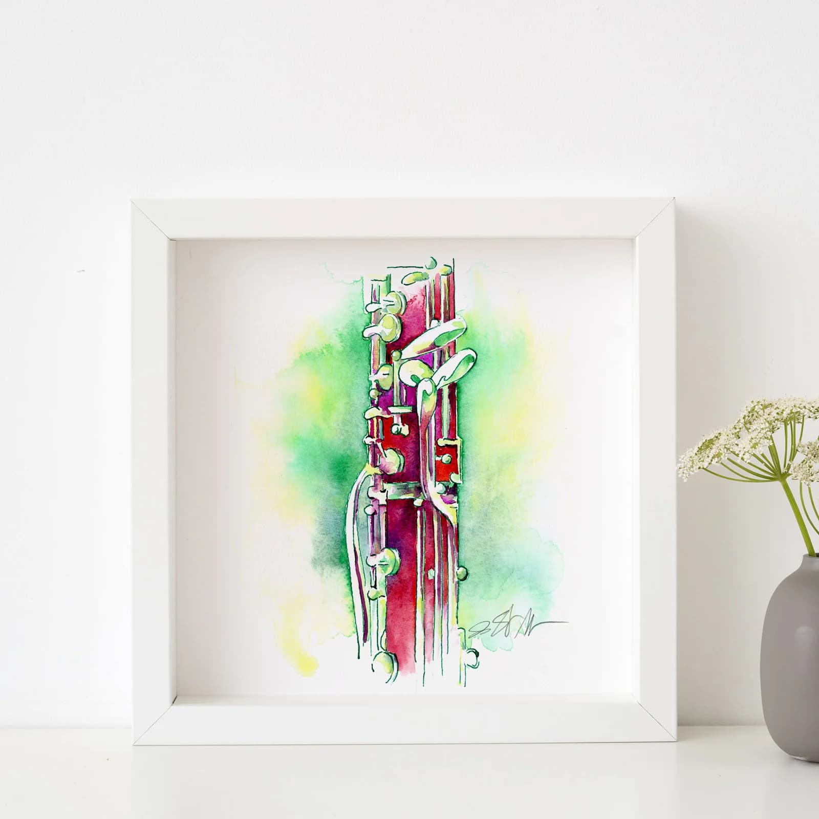 Jamie Hansen’s English Horn in Raspberry displayed in a white frame beside flowers.